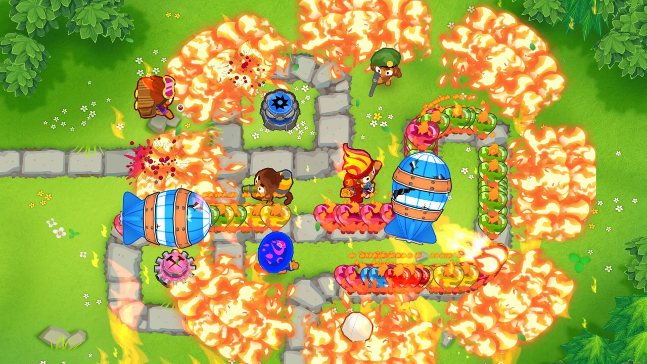 The featured image for our Bloons TD 6 Update 36 guide, featuring a screenshot of the game. The screenshot shows a top-down angle of a player defending their towers with bloons.
