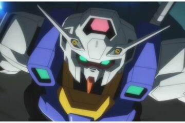 The image shows a Gundam looking up. He has spikes protruding from his helmet and heavy blue shoulder pads.